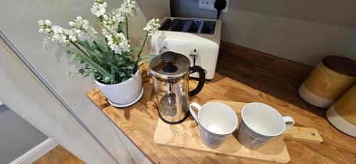 a table with a coffee maker and a vase of flowers at Place to stay Market Rasen in Market Rasen