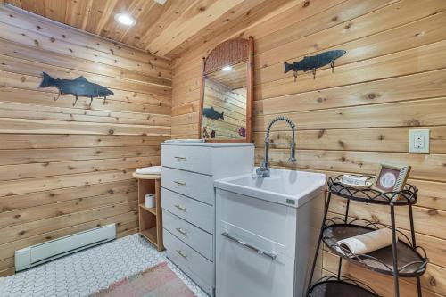 a log cabin bathroom with a sink and a stove at Michigan Cabin Retreat 5 Mi to Sturgeon Bay Beach in Pellston