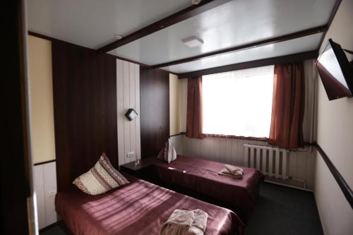 a hotel room with two beds and a window at Guest House Podobovets 2000 in Podobovets