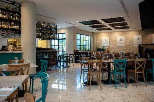 um restaurante com mesas e cadeiras e um bar em XVI Suites - Adults Only em Naxxar