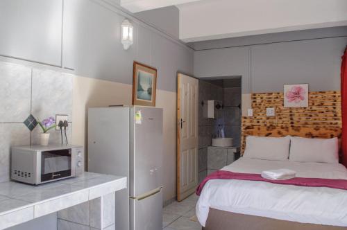 a small bedroom with a bed and a microwave at OceanLife Accommodation Luderitz in Lüderitz