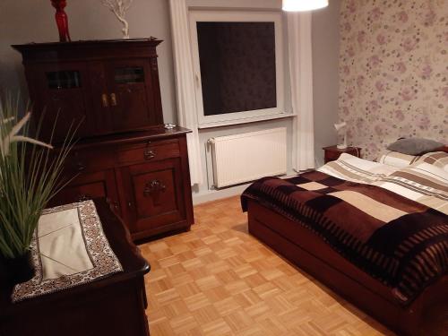 ストロニエ・シロンスキエにあるLeśna Strugaのベッドルーム1室(ベッド1台、ドレッサー、窓付)