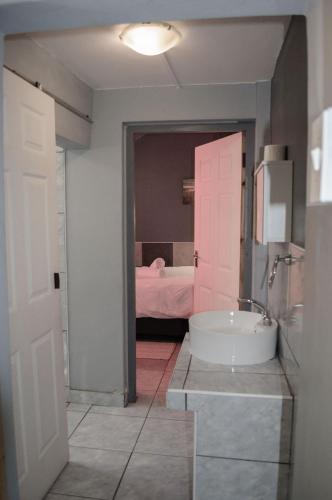 a bathroom with a sink and a bedroom with a bed at OceanLife Guesthouse and Restaurant Lüderitz in Lüderitz