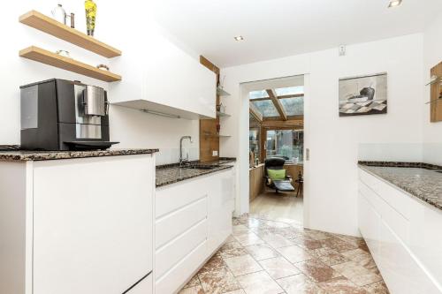 a kitchen with white cabinets and granite counter tops at Bayern Chalets bei Salzburg und Berchtesgaden mit Whirlpool und Sauna in Ainring