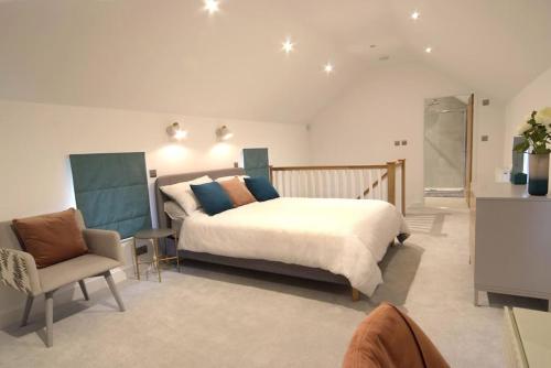 1 dormitorio con 1 cama grande y 1 silla en Beautiful barn conversion with easy access to York, en Selby