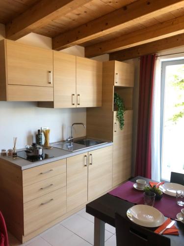 a kitchen with wooden cabinets and a dining table at BE HOME Fiera in Pero