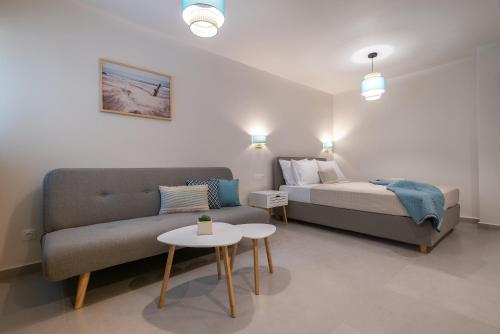 a bedroom with a bed and a couch and a table at ALMIRA Studios Limnos 3 in Myrina