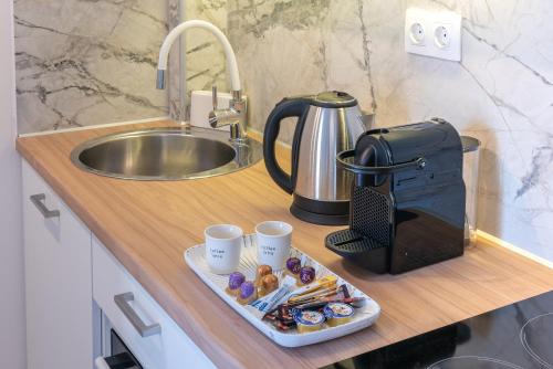 a kitchen counter with a tray of donuts and coffee cups at ALMIRA Studios Limnos 3 in Mirina