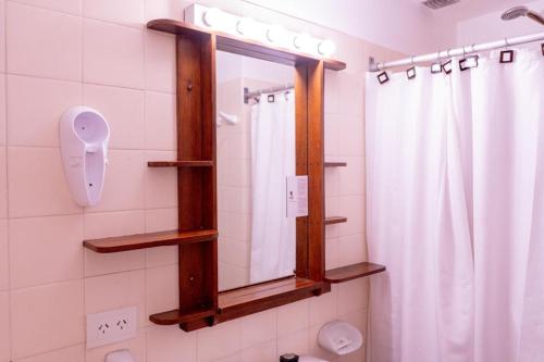 a bathroom with a mirror and a shower curtain at Hotel Centro SMANDES in San Martín de los Andes