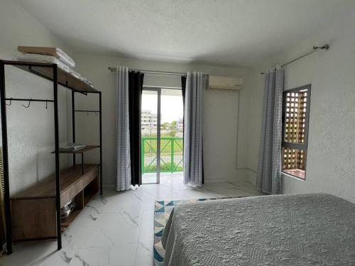um quarto com uma cama e uma grande janela em Sossego na praia mais charmosa de Floripa em Florianópolis