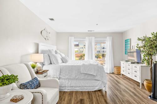 a white bedroom with a white bed and a white couch at Villa Capriani Condo with Direct Beach Access! in North Topsail Beach
