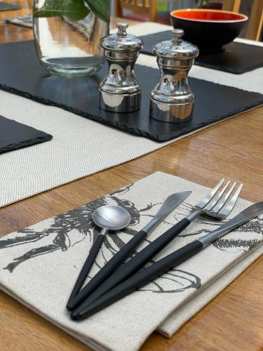 stół ze srebrnymi naczyniami na górze stołu w obiekcie Clachan Garden B&B w mieście Garve