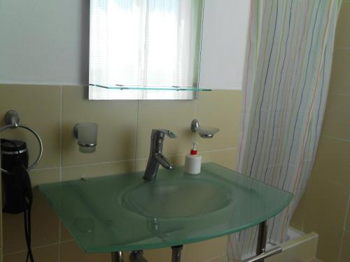 a bathroom with a green sink and a mirror at Maggy's House in La Romana