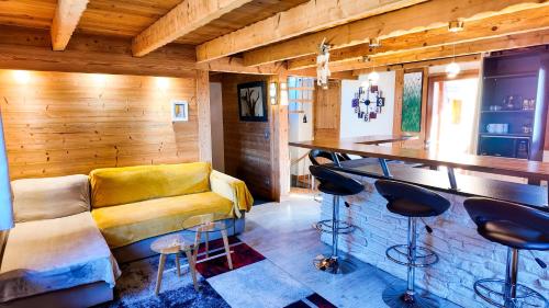 uma sala de estar com um sofá amarelo e um bar em Le Grenier 1821 - Mini chalet - Centre village - AravisTour em Saint-Jean-de-Sixt