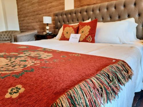 a bedroom with a large bed with a red blanket at Luna de Cafayate Hotel Boutique in Cafayate