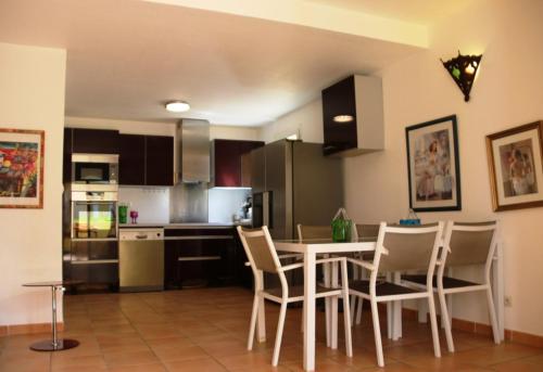 une cuisine avec une table et des chaises dans une pièce dans l'établissement Village naturiste - Jardin de la Palmeraie - Villa 2 chambres -, au Cap d'Agde