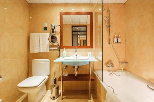 a bathroom with a toilet and a sink and a shower at Holiday Inn Lisbon-Continental, an IHG Hotel in Lisbon