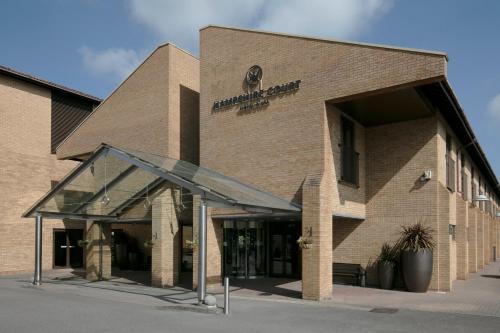 a brick building with a sign on the front of it at Hampshire Court Hotel & Spa in Basingstoke