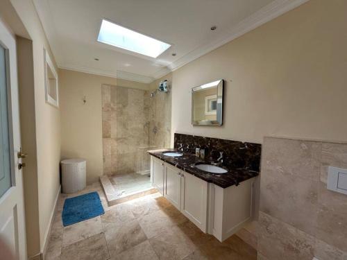 a large bathroom with a sink and a shower at The Yellow House in Cape Town