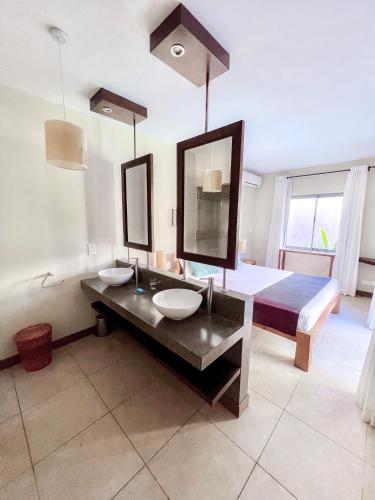 a bathroom with two sinks and a bed and a mirror at Tropical Villa - 3 Bedrooms in the heart of Grand-Baie in Grand Baie