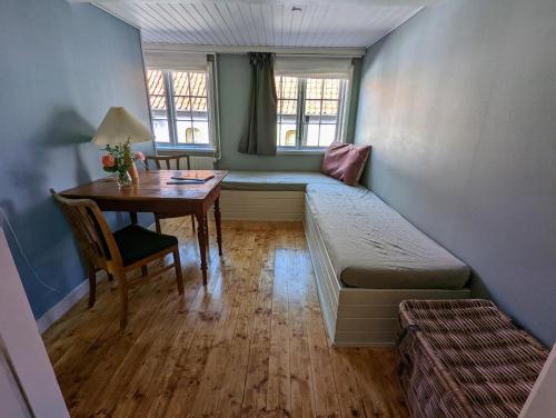 een kamer met een bed, een bureau en een tafel bij Pensionat Næsgaarden in Allinge