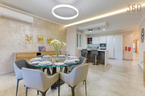 een eetkamer en een keuken met een tafel en stoelen bij Luxury 3BR home in St Julians with private terrace by 360 Estates in Taʼ Ċikkun
