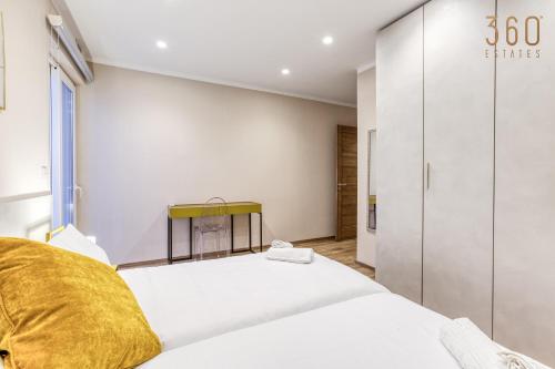 a bedroom with a large white bed with a yellow pillow at Luxury 3BR home in St Julians with private terrace by 360 Estates in Taʼ Ċikkun