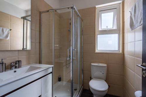 uma casa de banho com um chuveiro, um WC e um lavatório. em Harbor 203 Stylish 1-Bedroom Apartment in Larnaca em Lárnaca
