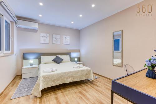 a white bedroom with a bed and a dresser at Luxury 3BR home in St Julians with private terrace by 360 Estates in Taʼ Ċikkun