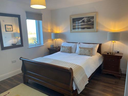 - une chambre avec un lit, 2 tables de nuit et 2 lampes dans l'établissement Ashlee Lodge P25 K6R6, à Shanagarry