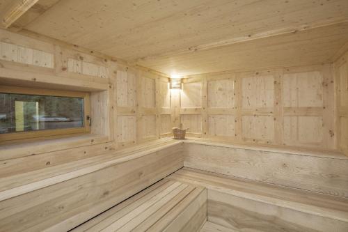 a sauna with wooden panel walls and a window at Bayern Chalets bei Salzburg und Berchtesgaden mit Whirlpool und Sauna in Ainring