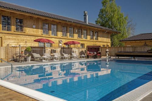 a large swimming pool in front of a building at Bayern Chalets bei Salzburg und Berchtesgaden mit Whirlpool und Sauna in Ainring