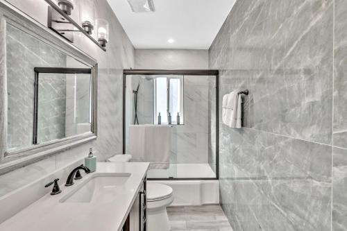 a bathroom with a sink and a toilet and a tub at Walkabout 6 Suite on Hollywood Beach with Ocean Views in Hollywood