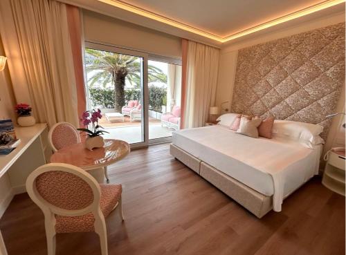 a bedroom with a bed and a table and chairs at Riviera Resort Hotel in Lignano Sabbiadoro