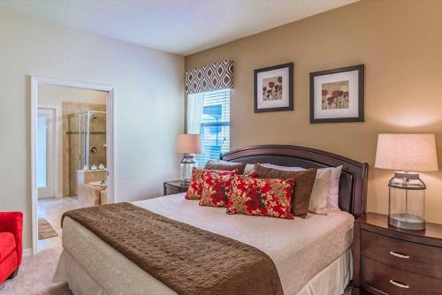 - une chambre avec un grand lit et des oreillers rouges dans l'établissement Villa Strawberry Coconut, à Kissimmee