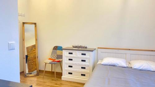 a bedroom with a bed and a dresser and a mirror at Filosoofi 1 Studio Apartments in Tartu