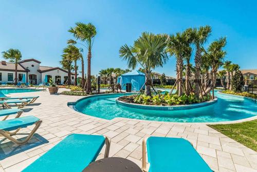 - une piscine avec des chaises bleues et des palmiers dans l'établissement Villa Strawberry Coconut, à Kissimmee