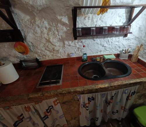 uma cozinha com um lavatório e uma bancada em Casa Cueva "El Mirador de Piedra" em Pegalajar