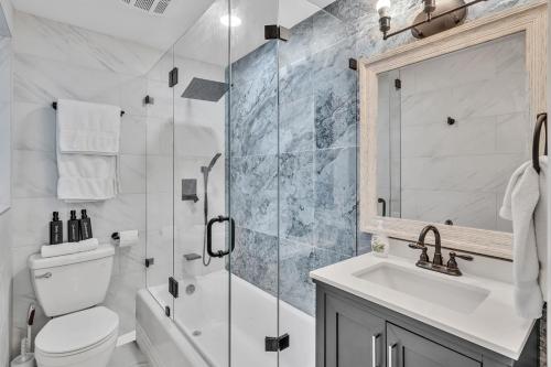 a bathroom with a shower and a toilet and a sink at Walkabout 3 King Suite on the Ocean in Hollywood Beach in Hollywood