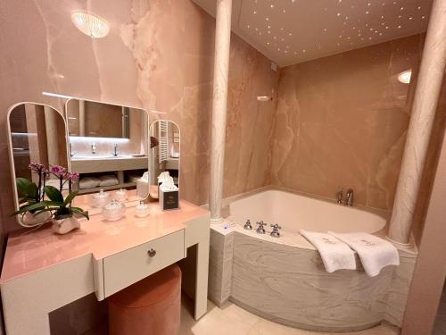 a bathroom with a tub and a sink at Riviera Resort Hotel in Lignano Sabbiadoro