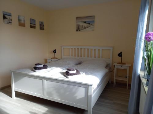 a bedroom with a white bed with hats on it at Ferienhaus Dat Landhuus 95158 in Rhauderfehn