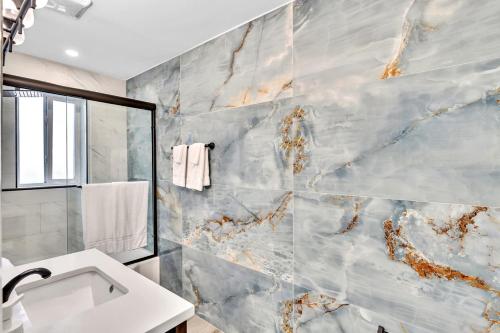 a bathroom with a sink and a marble wall at Walkabout 2 Oceanfront Suite on Hollywood Beach in Hollywood
