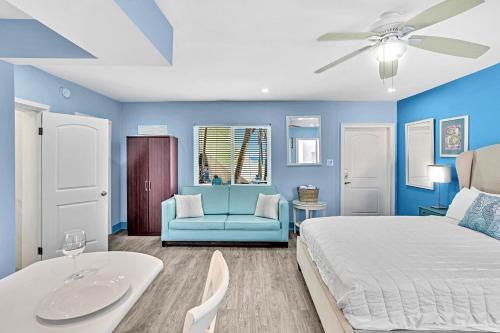 Walkabout 2 Oceanfront Suite on Hollywood Beach في هوليوود: غرفة نوم زرقاء مع سرير وكرسي أزرق