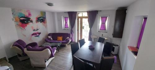 sala de estar con mesa y sillas moradas en Prima Casa, en Oradea
