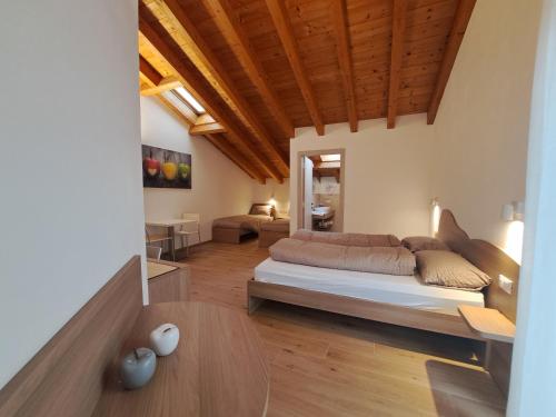 a living room with a bed and a table at Agritur Clementi in Nave San Rocco