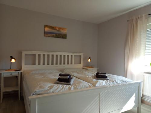 a bedroom with a white bed with two pillows on it at Ferienhaus Dat Landhuus 95158 in Rhauderfehn