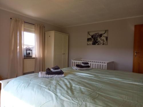 a bedroom with a large bed with two hats on it at Ferienhaus Dat Landhuus 95158 in Rhauderfehn