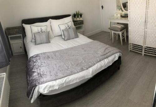 a bedroom with a large bed with pillows at Downtown Cottage Conwy in Conwy