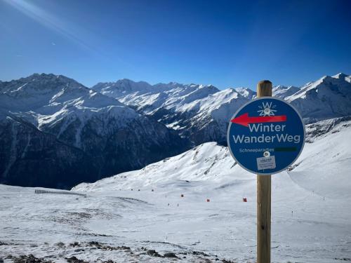 a sign on top of a snow covered mountain at Das schräge Häusl in Rangersdorf