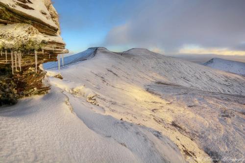 Una montaña nevada con nieve en el costado. en James' Place at The Park, en Merthyr Tydfil